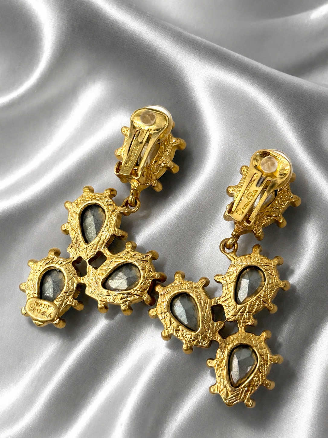 Back view of gold-tone green rhinestone clip-on earrings with clip mechanisms