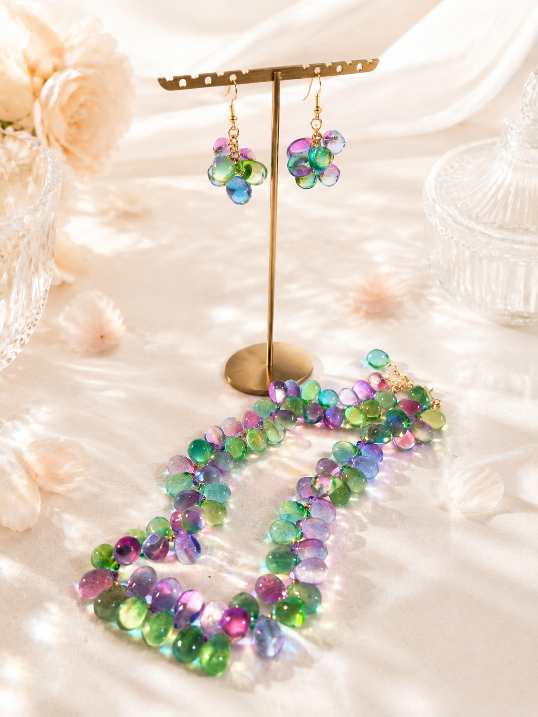 Gold-tone multicolor glass necklace and hook earrings set flat lay view