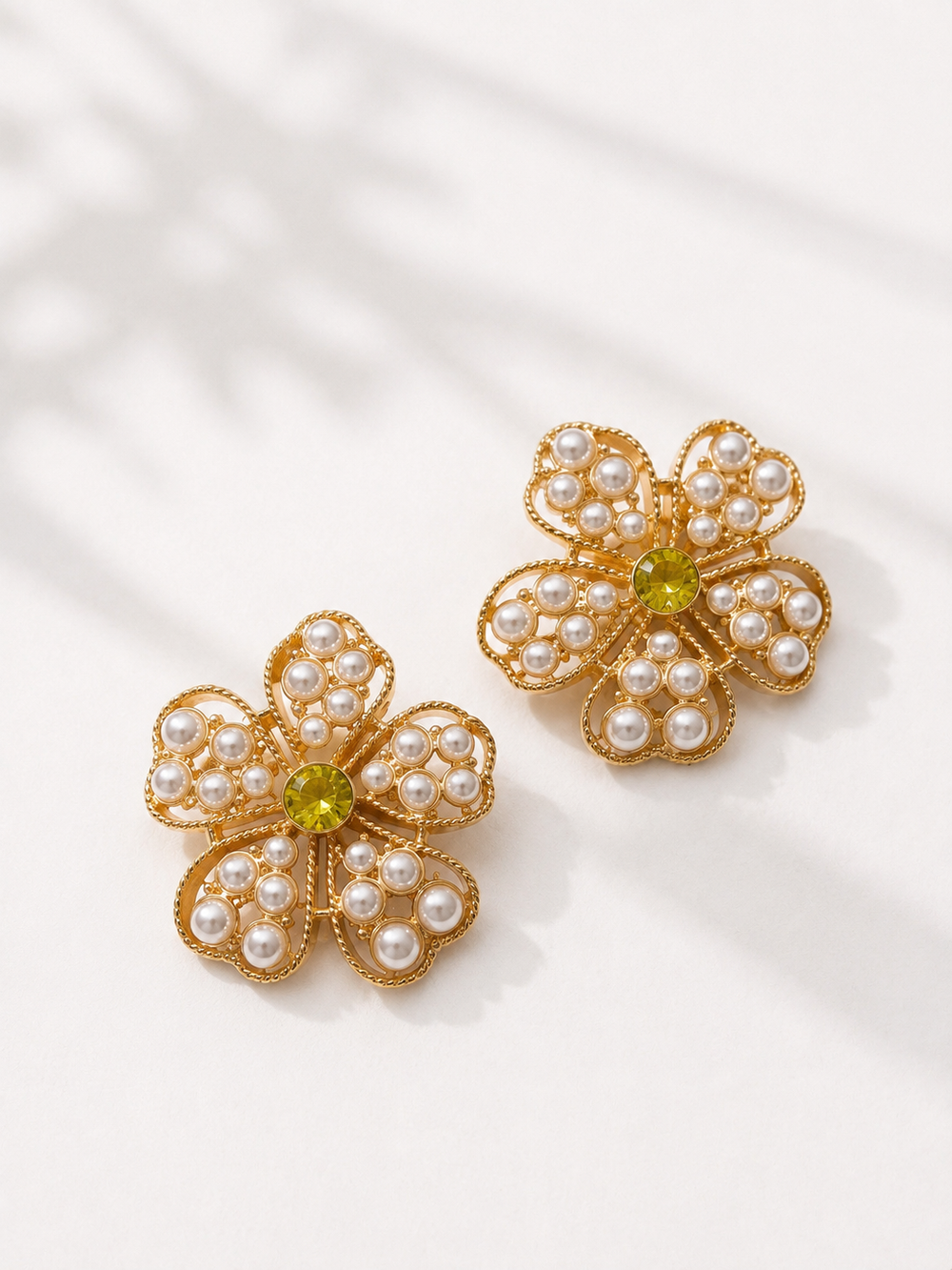 Gold-tone pearl-style flower stud earrings with yellow crystal-style center
