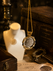Gold-tone reversible Greek coin-style pendant necklace dark editorial view