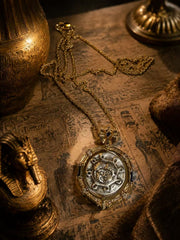 Gold-tone reversible Greek coin-style pendant necklace tabletop editorial view