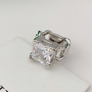 Silver-tone chain-link ring with clear square accent on white surface