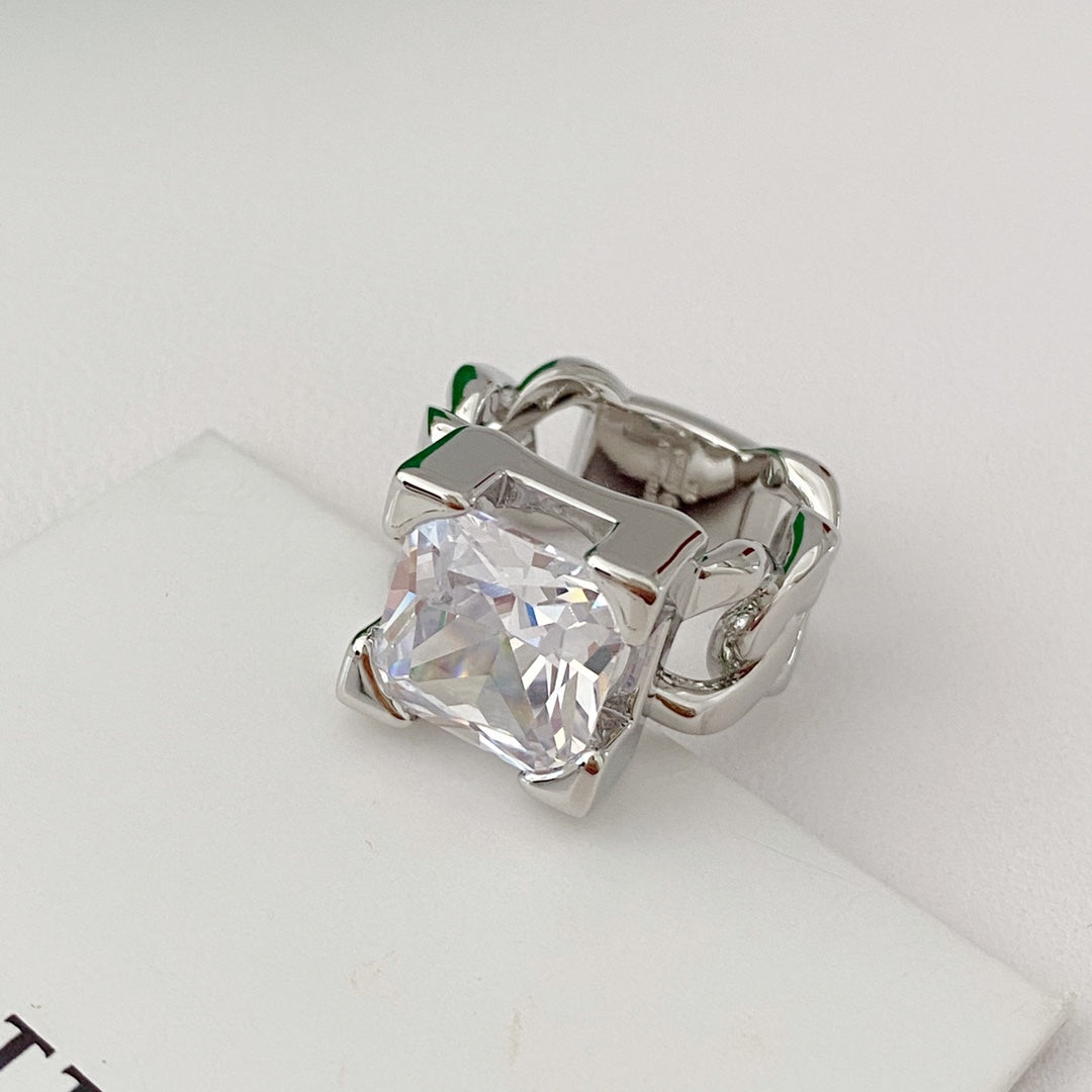 Silver-tone chain-link ring with clear square accent on white surface
