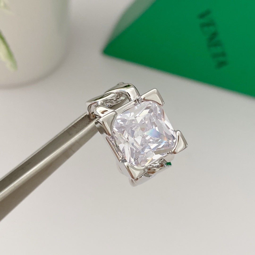Side view of silver-tone chain-link ring with clear square accent