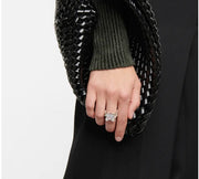 Silver-tone chain-link ring with clear square accent worn on hand