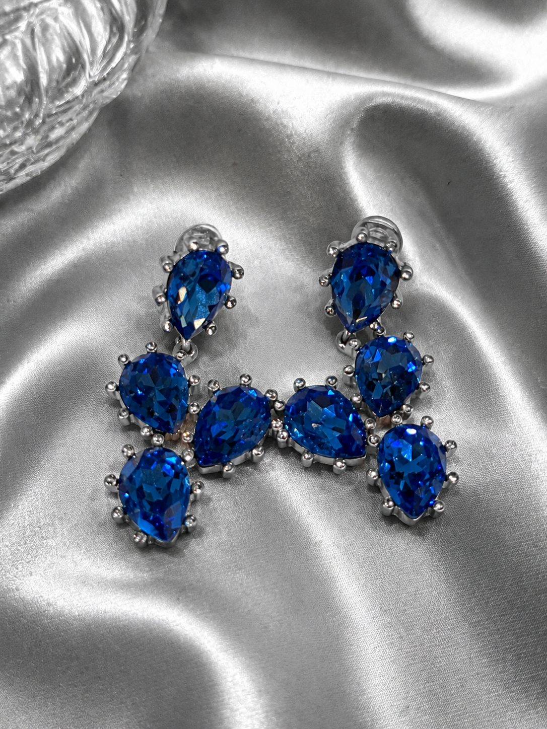 Close-up of silver-tone blue rhinestone clip-on earrings