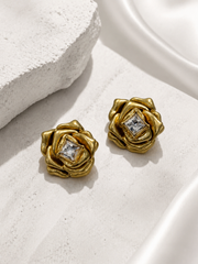 Gold-tone rose-shaped statement stud earrings with clear crystal-style center, front view