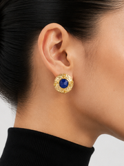 Textured gold-tone clip-on statement earrings with deep blue centers detail view