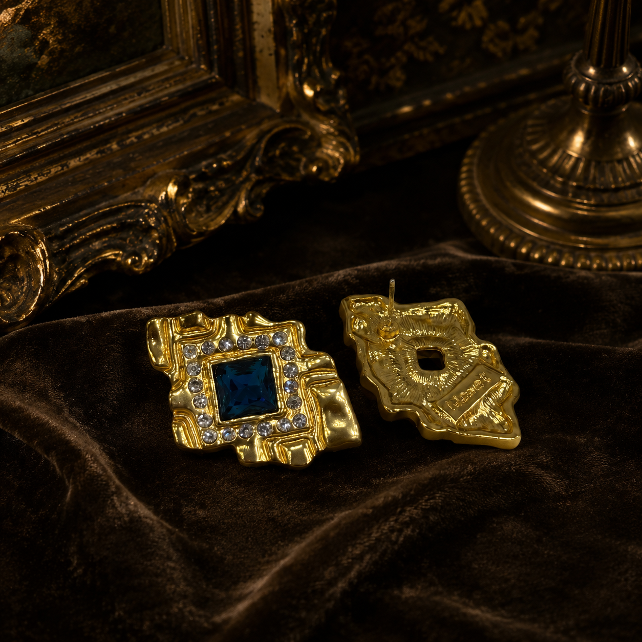 Gold-tone rectangular stud earring showing front and back views with a royal-blue stone-style center