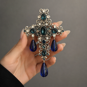 Lake blue crystal glass cross tassel clip-on earring shown in hand