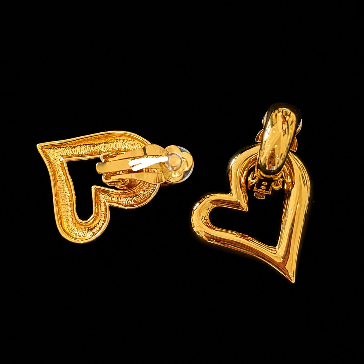 Back view showing the clip-on closures of gold-tone open heart earrings