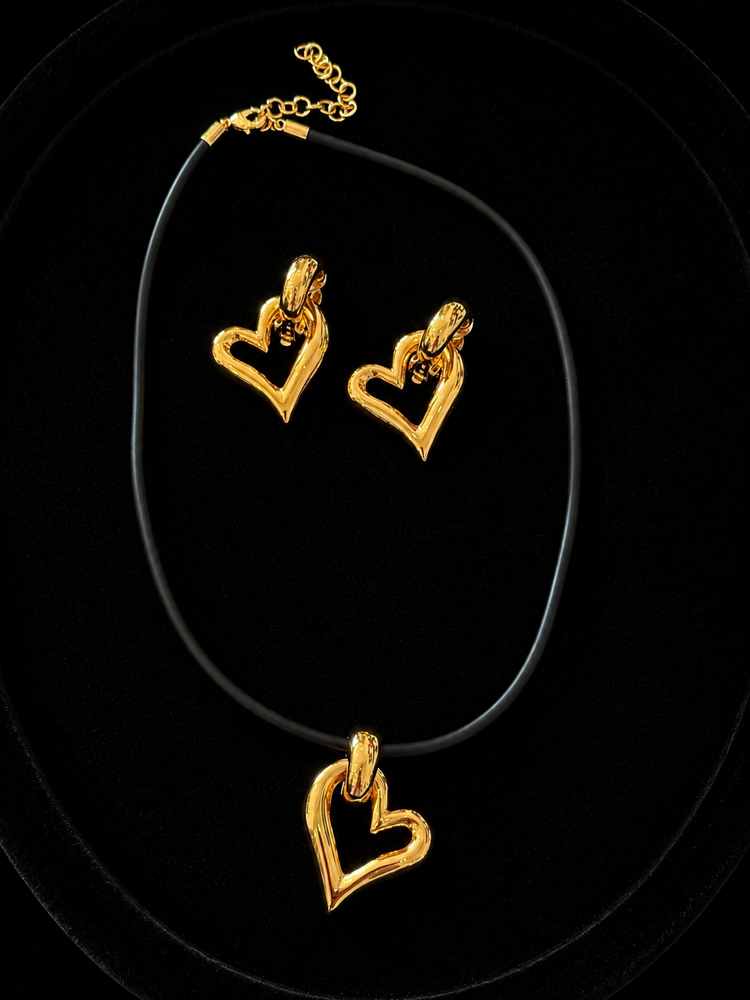Gold-tone open heart adjustable cord necklace with matching clip-on earrings shown for styling