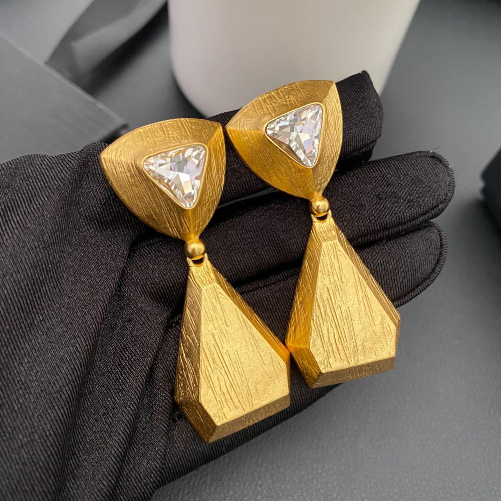 Vintage-inspired rhinestone geometric teardrop clip-on earrings held on a black glove