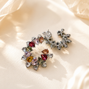 Back view of white rhinestone-style statement stud earrings with multicolor crystal-style accents