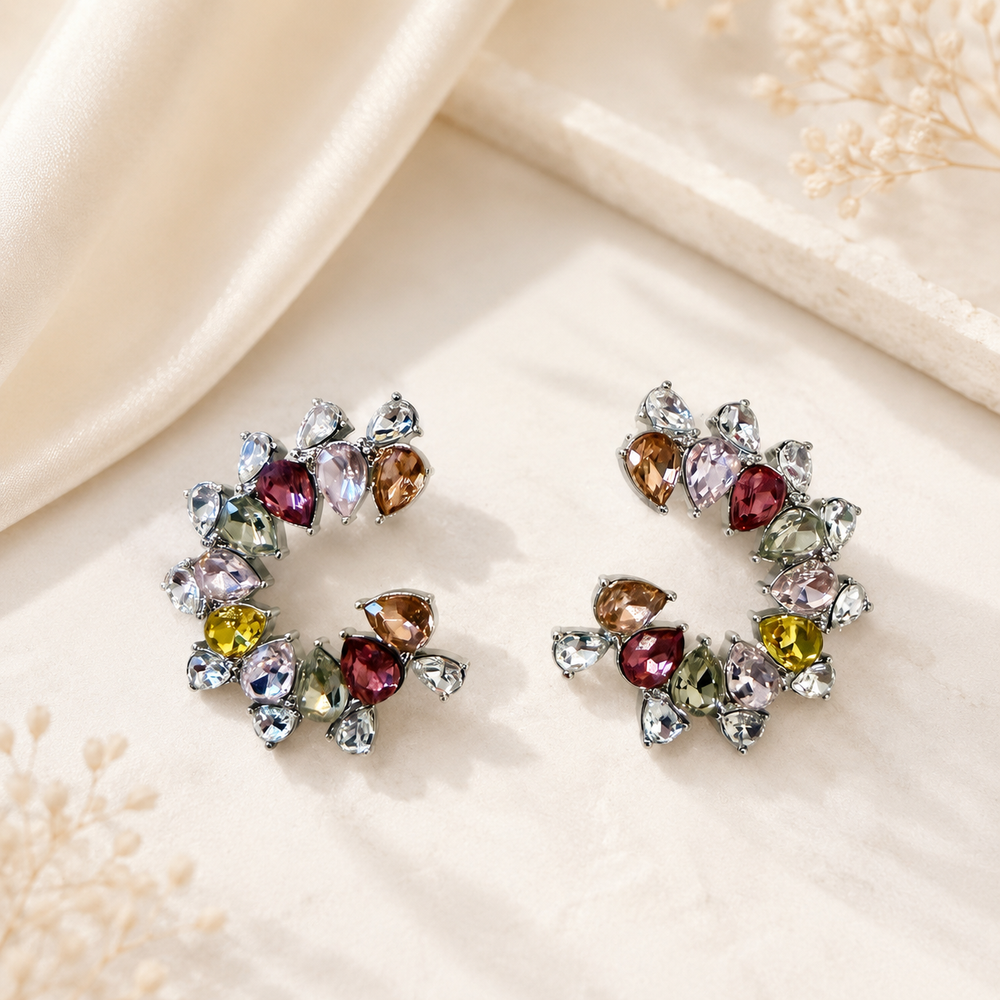 Front view of white rhinestone-style statement stud earrings with multicolor crystal-style accents